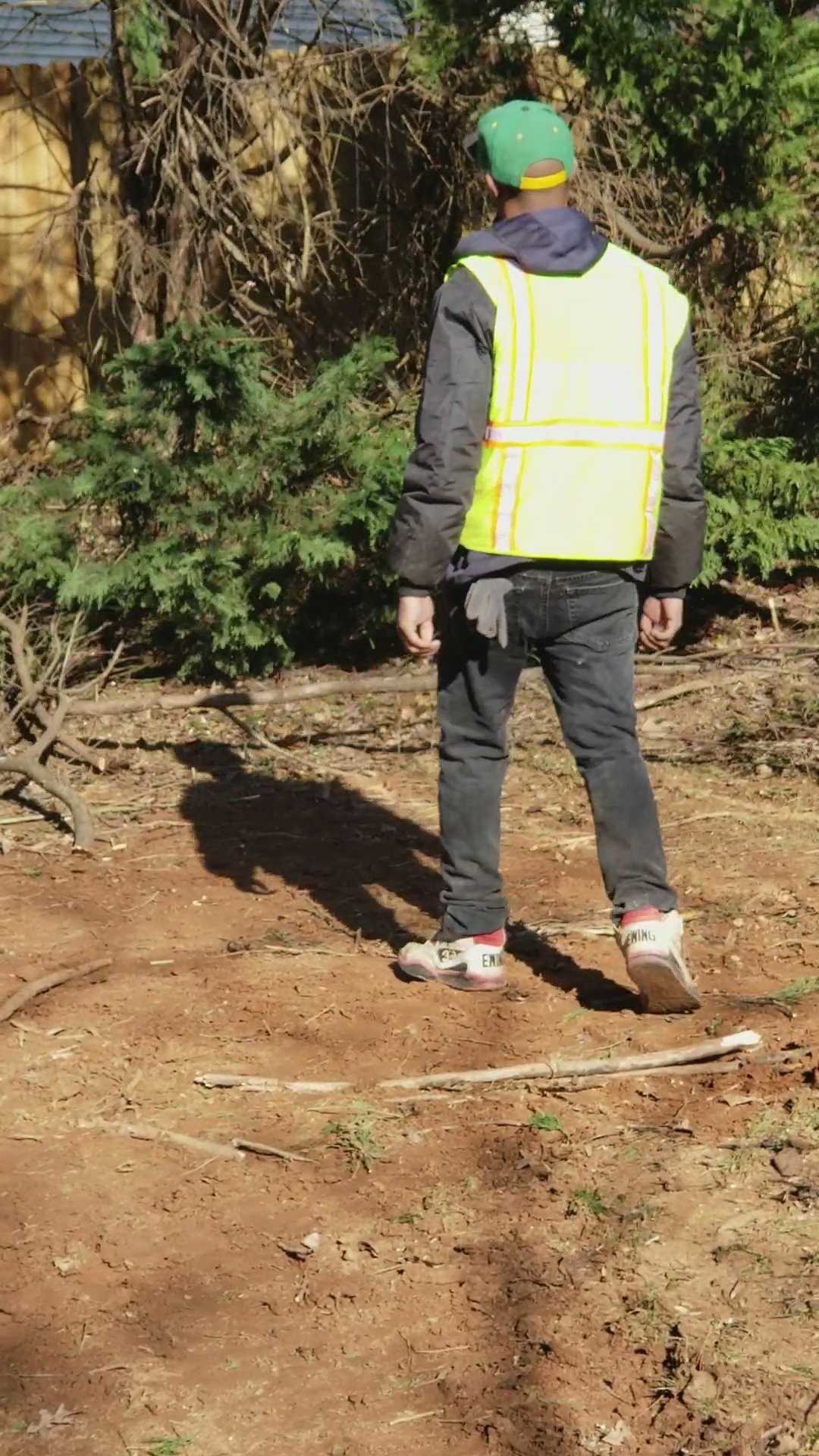 Heflin Tree Service crew member in high-visibility safety vest documenting brush and debris during a residential land-clearing job in metro Atlanta